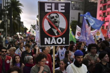 Protesters in the streets against Bolsonaro. "Not him,"says the sign